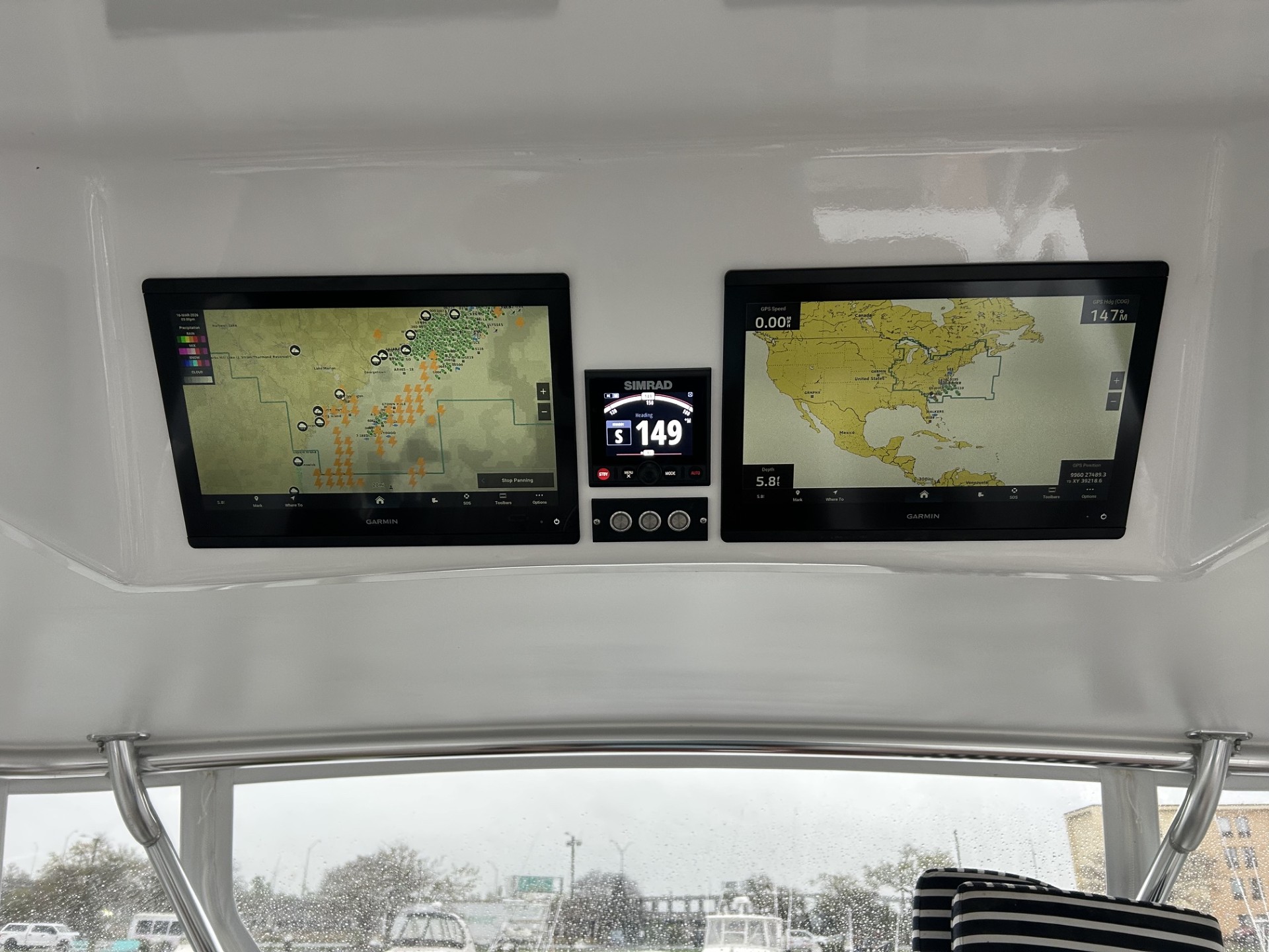 Garmin multifunction displays with centrally mounted Simrad instrumentation at a marine helm